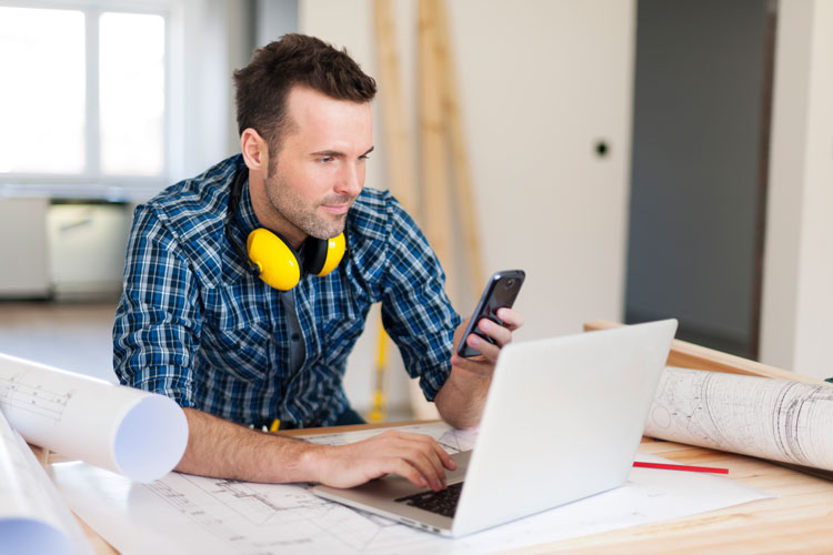 contractor on laptop & phone